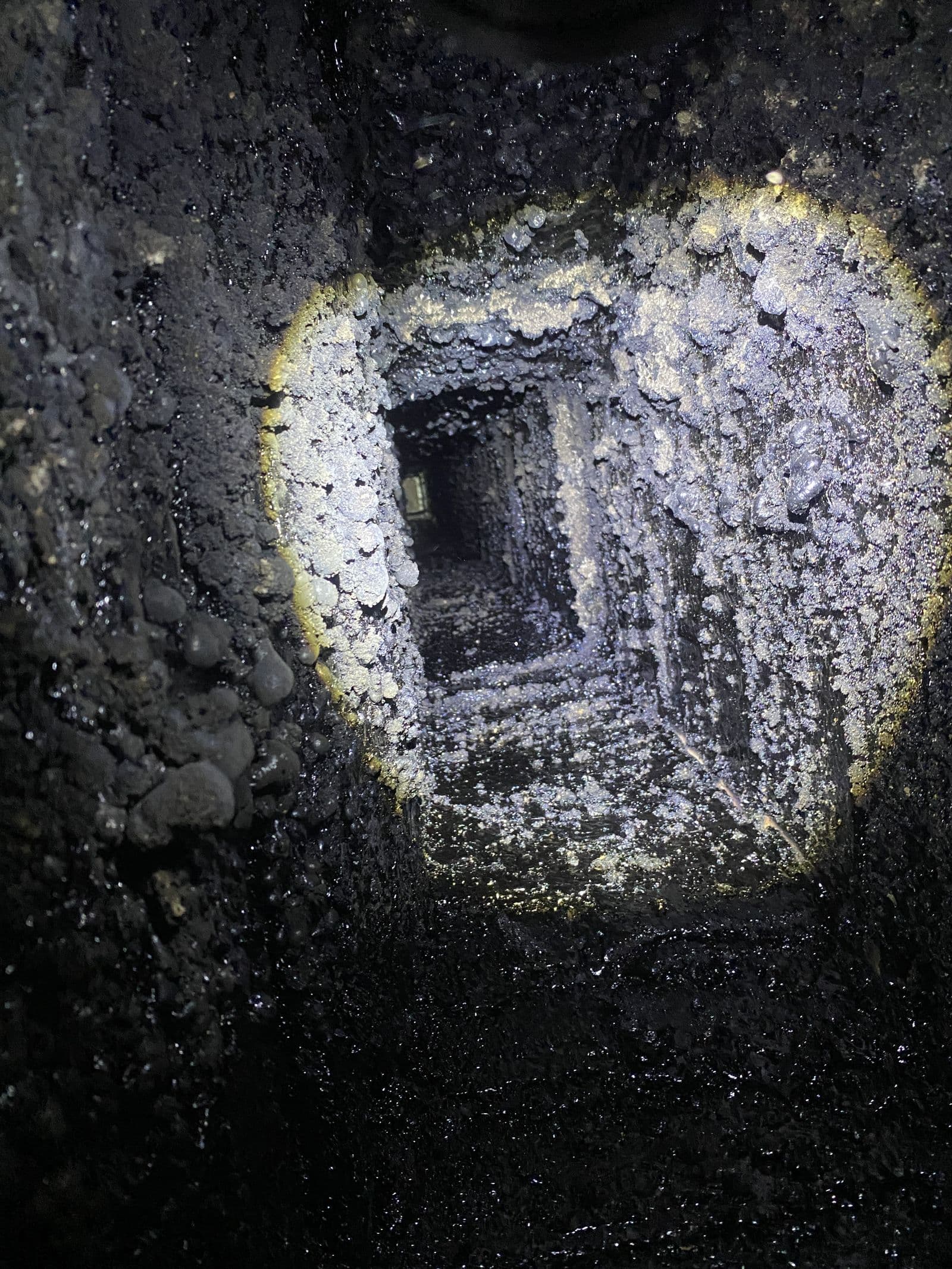 The interior of a flue coated in creosote before cleaning