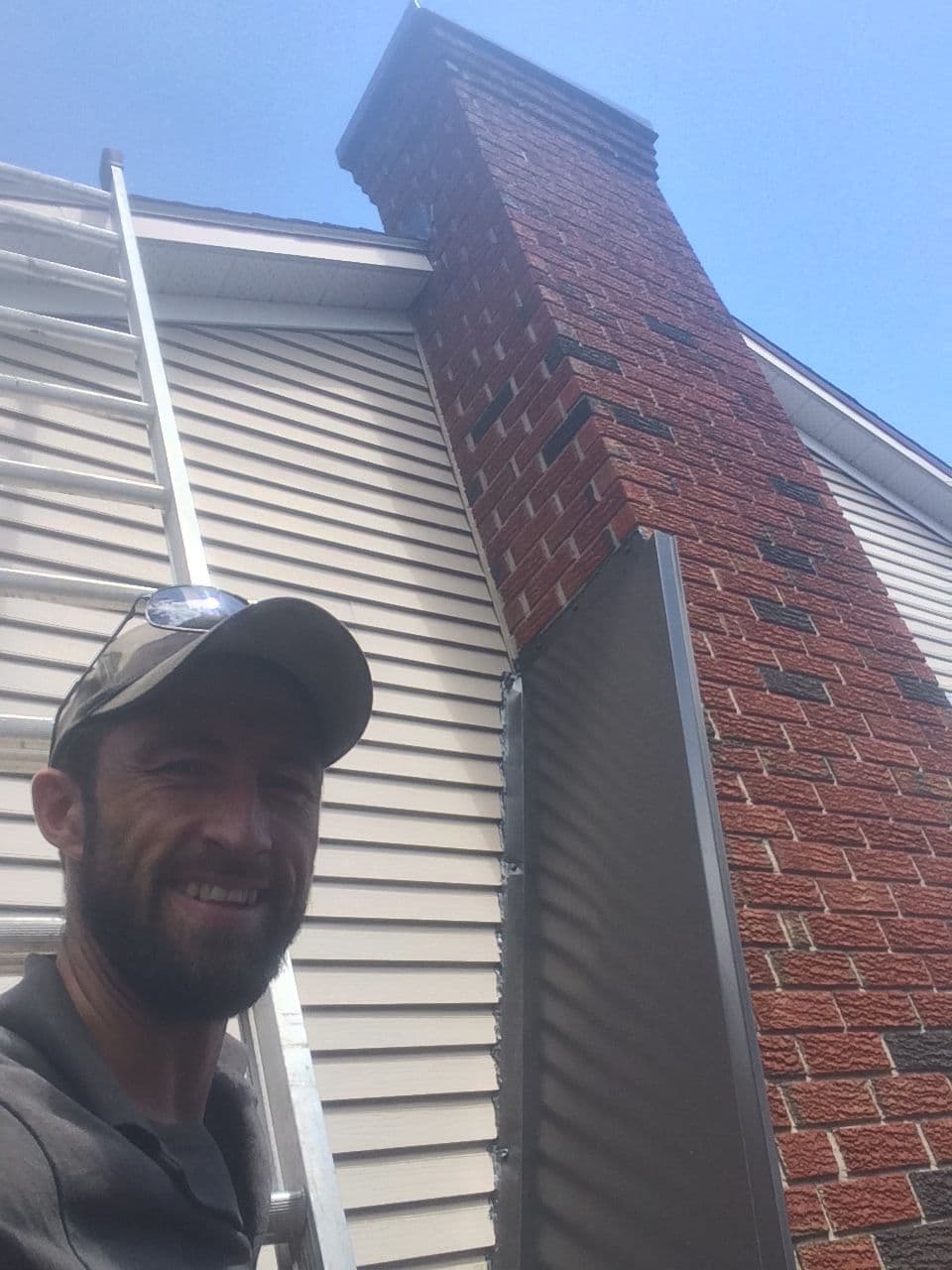 Jacob beside a chimney with newly installed flashing