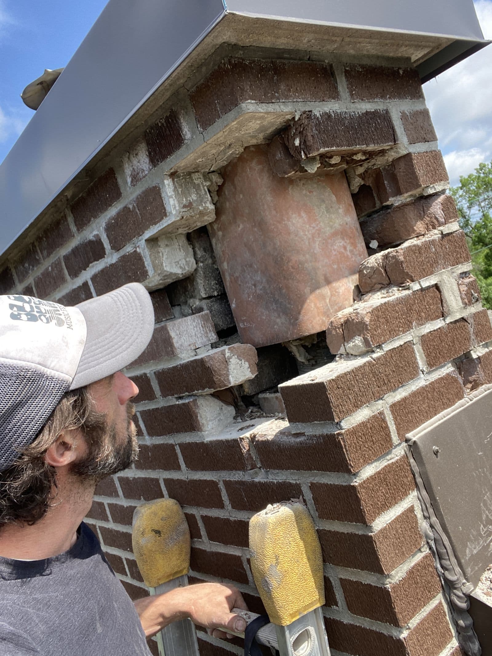 Jacob inspecting a damaged flue tile during a repair