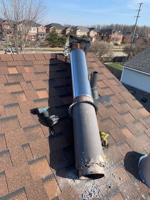 Installing a new chimney liner section on an Ottawa rooftop