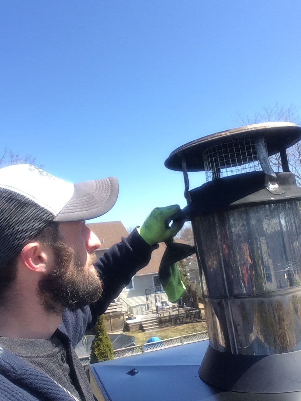 Jacob Dixon adjusting a chimney cap on an Ottawa rooftop